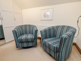 A snug with two striped armchairs and a radiator at Chestnut Barn Aislaby near Whitby