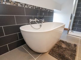 A bathroom with a bathtub and a shower at Chestnut Barn Aislaby near Whitby