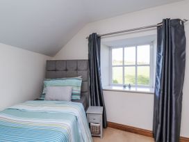 A bedroom with a bed and window at Chestnut Barn Aislaby near Whitby