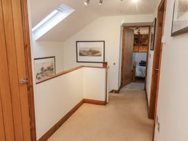 A hallway with paintings on the wall and a door at Chestnut Barn Aislaby near Whitby
