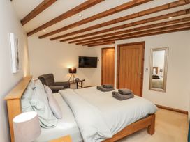 A bedroom with a bed and armchair at Chestnut Barn Aislaby near Whitby