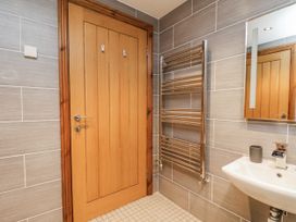 A bathroom with a door sink and heated towel rail at Chestnut Barn Aislaby near Whitby