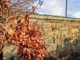 A stone wall with dry leaves and branches at Chestnut Barn Aislaby near Whitby