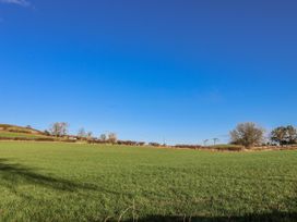 A clear field with trees and a farmhouse at Chestnut Barn Aislaby near Whitby