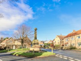 A view of a monument surrounded by houses at Chestnut Barn Aislaby near Whitby