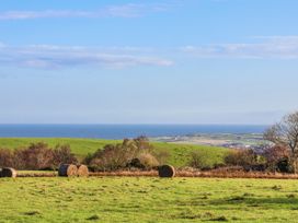 A landscape with hills and hay bales near the ocean at Chestnut Barn Aislaby near Whitby