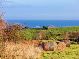 A view of hay bales on grass with the sea in the background at Chestnut Barn Aislaby near Whitby