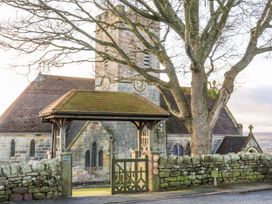 A church with a clock tower and a gate at Chestnut Barn Aislaby near Whitby