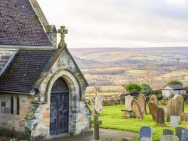 A church near a graveyard overlooking hills at Chestnut Barn in Aislaby near Whitby