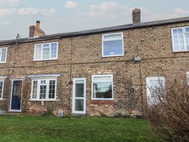 Exterior view of a brick house with windows and a door at Daffodil Cottage in York