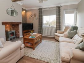 A living room with a sofa and a coffee table at Daffodil Cottage in York