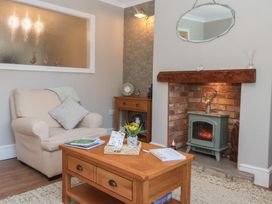 A living room with a fireplace and armchair at Daffodil Cottage in York