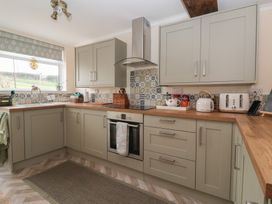 A kitchen with cabinets and appliances at Daffodil Cottage in York