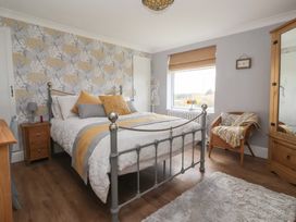 A bedroom with a bed and bedside table at Daffodil Cottage in York
