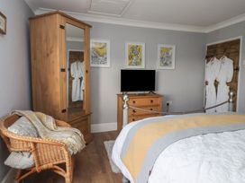 A bedroom with a wardrobe, television and a chair at Daffodil Cottage in York