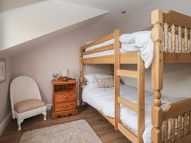 A bedroom with a bunk bed and nightstand at Daffodil Cottage in York
