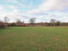 An open field with trees and houses in the background at Daffodil Cottage in York