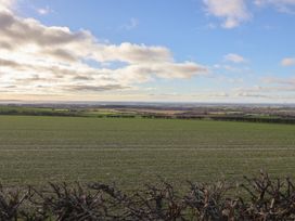 A view of a field with a hedge and cloudy sky at Daffodil Cottage in York