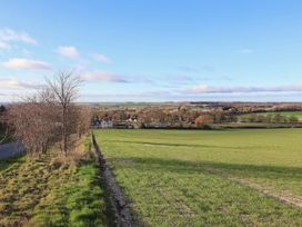 A landscape view of a field and distant houses at Daffodil Cottage York