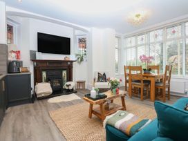 A living room with a fireplace and dining area at The Magnolia in Rhos-On-Sea