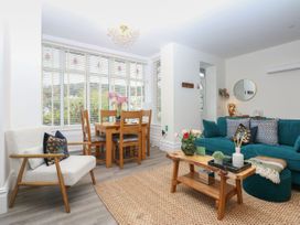 A living room with a dining area and a green sofa at The Magnolia in Rhos-On-Sea