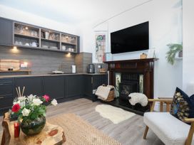 A kitchen with furniture and appliances at The Magnolia in Rhos-On-Sea