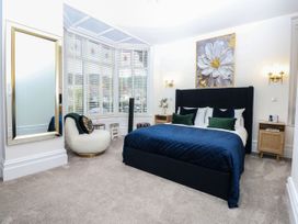 A bedroom with a bed and a chair at The Magnolia in Rhos-On-Sea