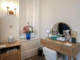 A bedroom with a vanity unit and flowers in a vase at The Magnolia in Rhos-On-Sea
