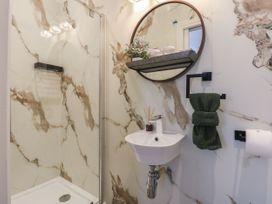 A bathroom featuring a shower, sink, and mirror at The Magnolia in Rhos-On-Sea