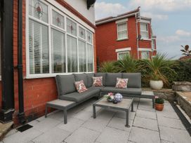 A patio area with a sofa and table at The Magnolia in Rhos-On-Sea