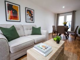 A living room with a sofa and dining table at Beech Cottages in Llanrwst