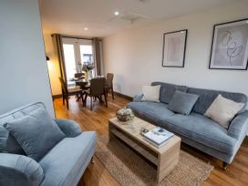 A living room with a sofa and dining table at Beech Cottages in Llanrwst