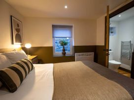 A bedroom with a bed and window at Beech Cottages in Llanrwst