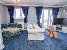 A living room with a couch, armchair and television at Sea Spray in Westward Ho!