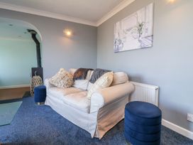 A living room with a sofa and wall art at Sea Spray in Westward Ho!