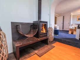 A living room with a fireplace and wood stove at Sea Spray Westward Ho!