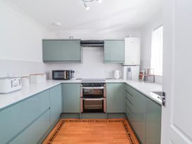 A kitchen with cabinets and appliances at Sea Spray in Westward Ho!