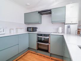 A kitchen with kitchen cabinets, oven, hob, kettle, and toaster at Sea Spray in Westward Ho!