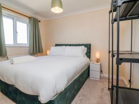 A bedroom with a bed and nightstand at Sea Spray in Westward Ho!