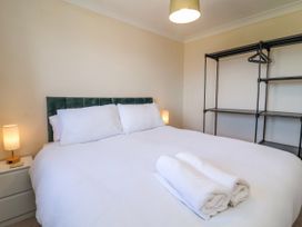 A bedroom with a bed and shelving unit at Sea Spray in Westward Ho!
