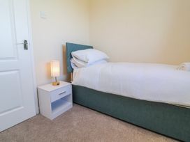 A bedroom with a bed and bedside table at Sea Spray in Westward Ho!
