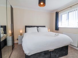 A bedroom with a bed and bedside table at Sea Spray in Westward Ho!