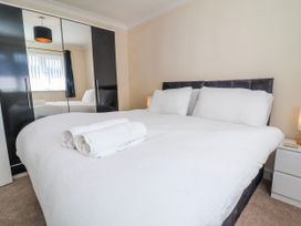 A bedroom with a bed and towels at Sea Spray in Westward Ho!