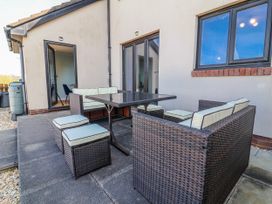 An outdoor seating area with a table and chairs at Sea Spray in Westward Ho!