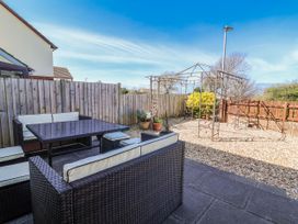A garden with outdoor furniture and a trellis at Sea Spray in Westward Ho!