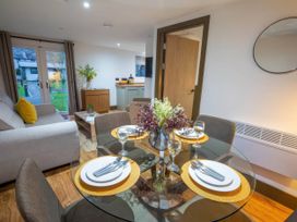 A dining area with a table set for meals at Fir Cottages in Llanrwst