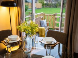 A dining room with a table and chairs at Fir Cottages in Llanrwst