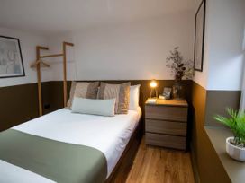 A bedroom with a bed and bedside table at Fir Cottages in Llanrwst