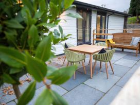 An outdoor seating area with a table and chairs at Fir Cottages in Llanrwst