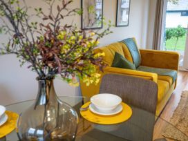A living room with a sofa and table set at Silver Birch Cottage in Llanrwst